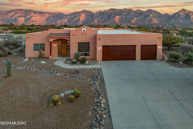 adobe home featuring a mountain view and a garage