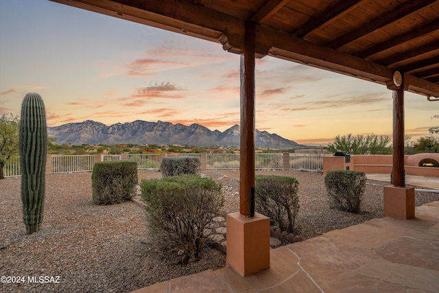 patio terrace at dusk featuring a mountain view