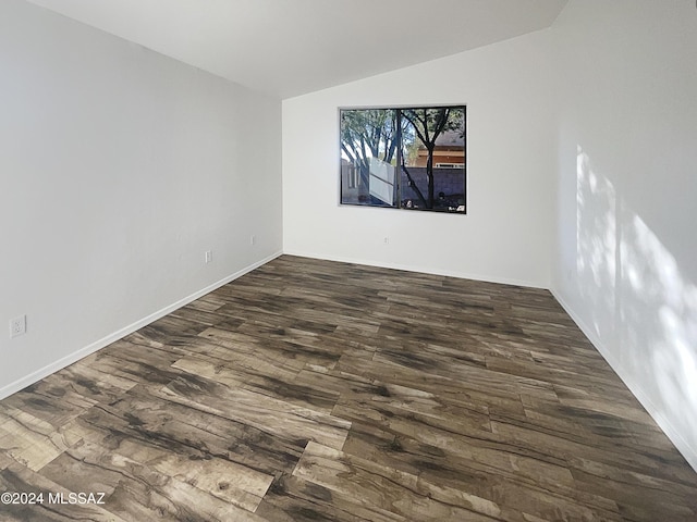 empty room featuring dark hardwood / wood-style flooring and vaulted ceiling