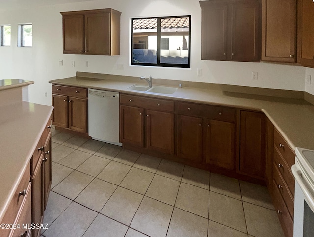 kitchen with white appliances, sink, and light tile patterned floors