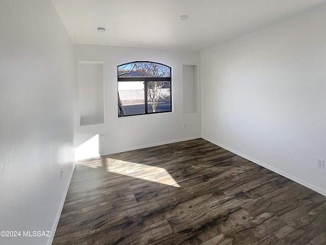 empty room with dark hardwood / wood-style flooring