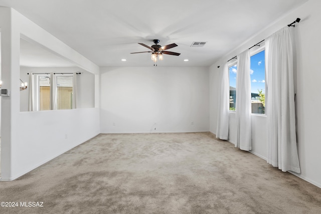 carpeted spare room with ceiling fan