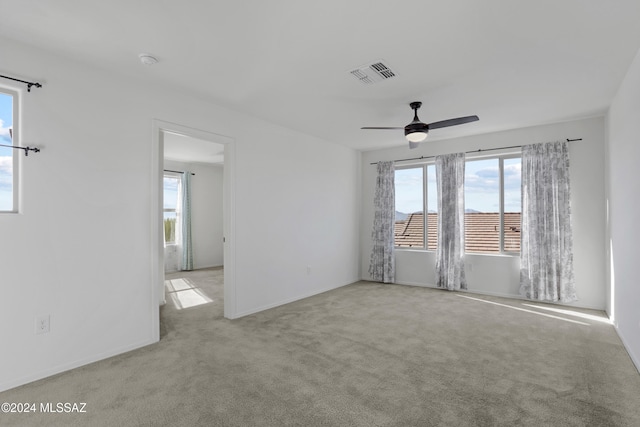 carpeted spare room with ceiling fan