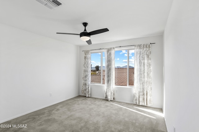 carpeted spare room featuring ceiling fan