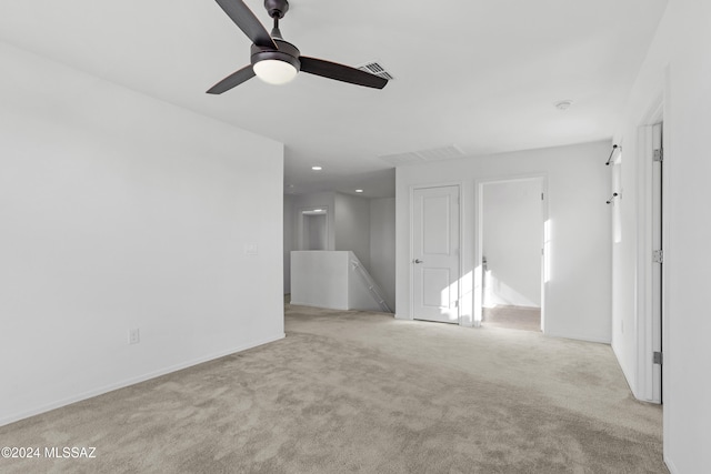 carpeted spare room featuring ceiling fan