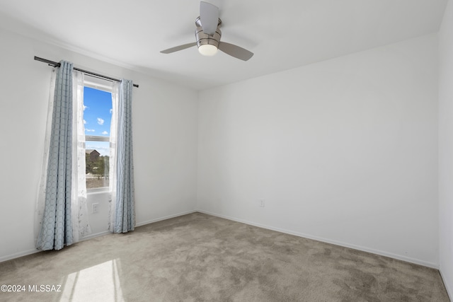 spare room featuring plenty of natural light, ceiling fan, and light colored carpet