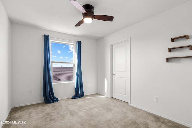 unfurnished room featuring light colored carpet and ceiling fan