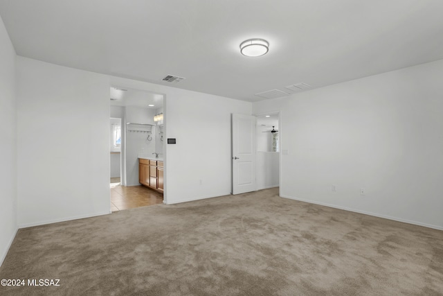 unfurnished room featuring light colored carpet