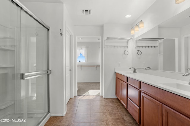 bathroom featuring tile patterned flooring, vanity, and a shower with shower door