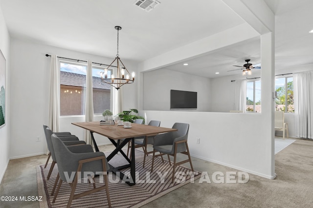 dining space featuring light carpet, ceiling fan with notable chandelier, and a wealth of natural light