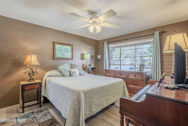 bedroom with hardwood / wood-style flooring, ceiling fan, and wood walls