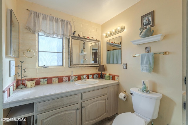 bathroom with decorative backsplash, vanity, and toilet