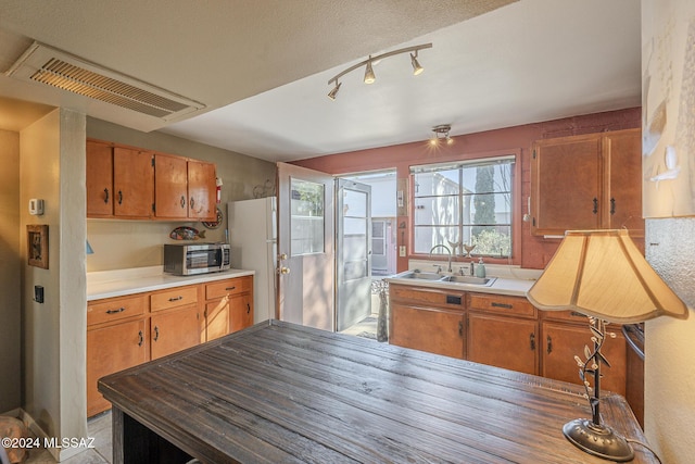 kitchen featuring sink, white fridge, and a textured ceiling