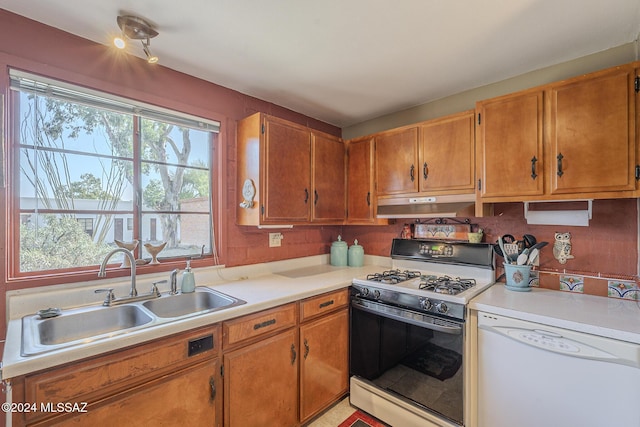 kitchen featuring white appliances, sink, a wealth of natural light, and tasteful backsplash