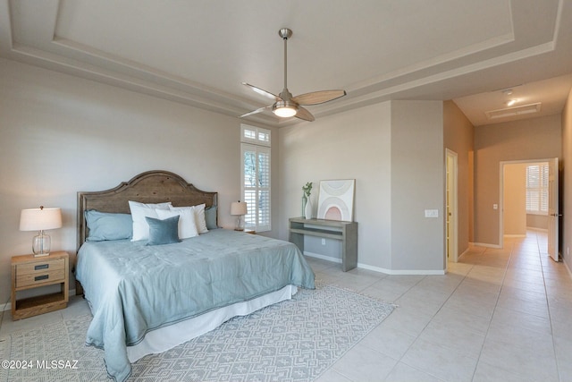 bedroom featuring a tray ceiling, ceiling fan, and light tile patterned flooring