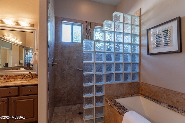 bathroom featuring vanity and independent shower and bath