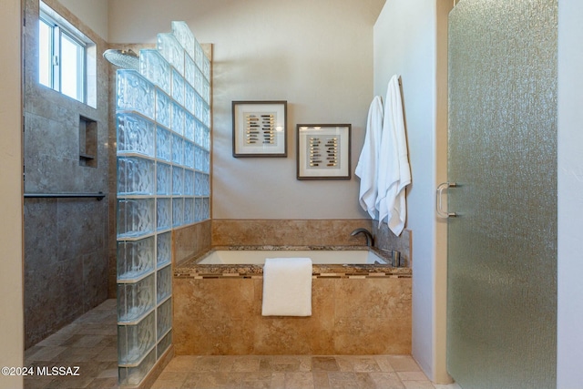 bathroom featuring independent shower and bath