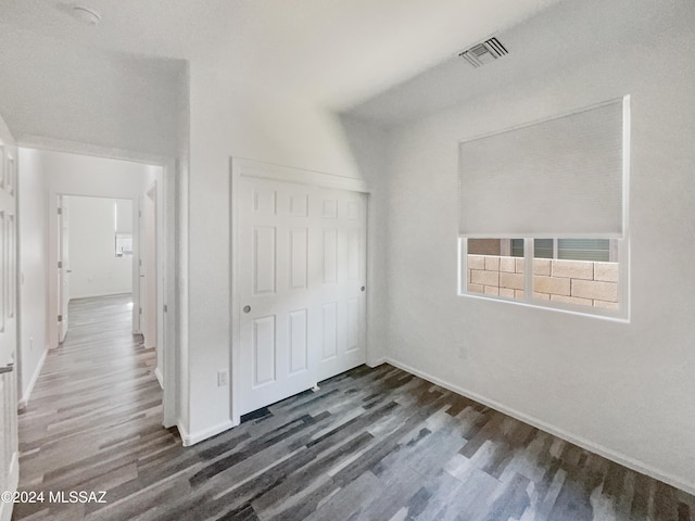 unfurnished bedroom featuring a closet and dark hardwood / wood-style floors