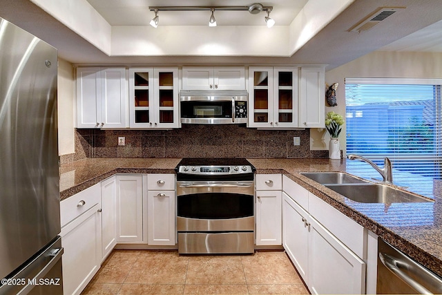 kitchen featuring appliances with stainless steel finishes, white cabinetry, and sink