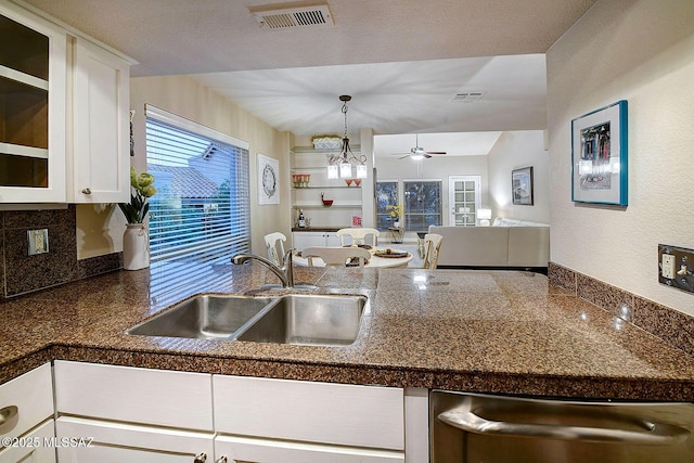 kitchen featuring white cabinetry, sink, dishwasher, hanging light fixtures, and ceiling fan with notable chandelier