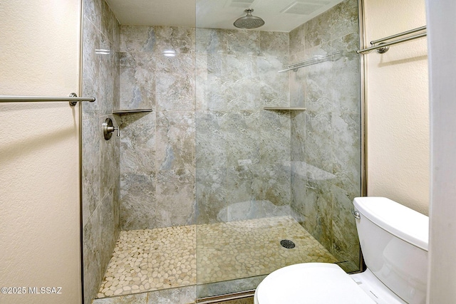 bathroom featuring toilet and tiled shower