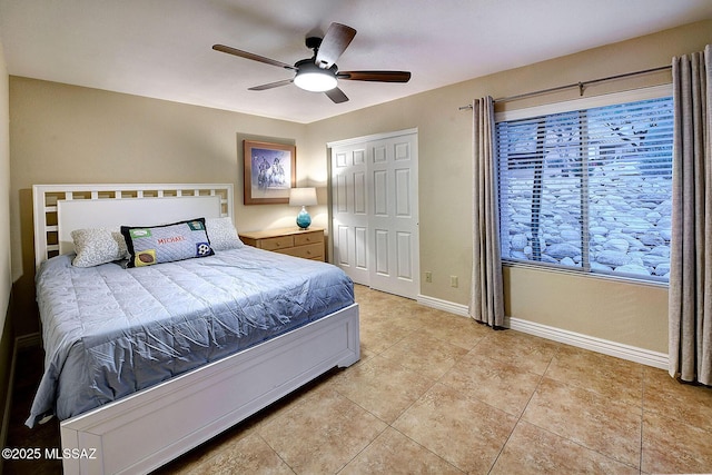 bedroom featuring ceiling fan, a closet, and light tile patterned flooring