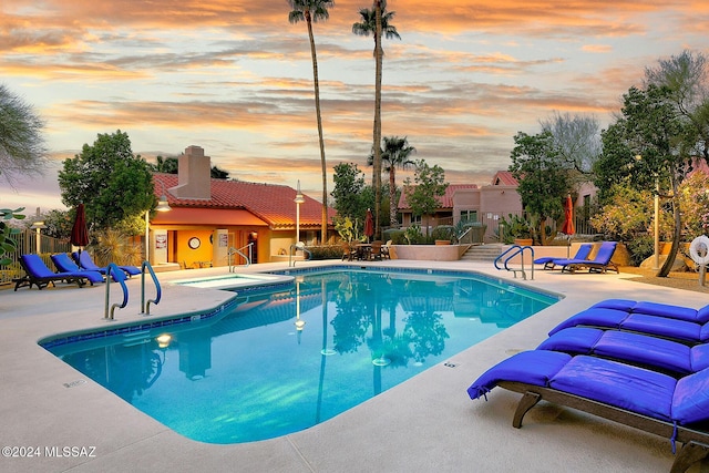 pool at dusk with a patio