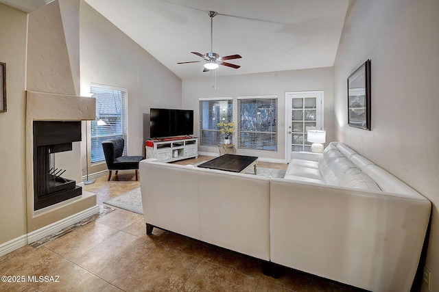 tiled living room featuring ceiling fan, a multi sided fireplace, and lofted ceiling