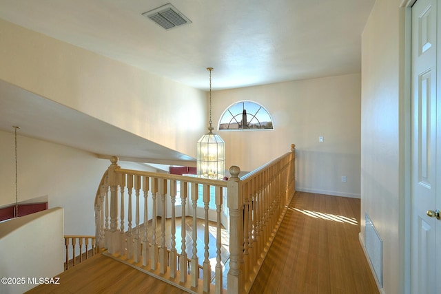 corridor with a chandelier and wood-type flooring