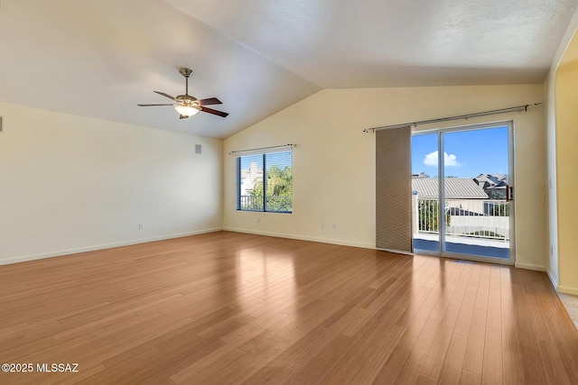 spare room with ceiling fan, lofted ceiling, and light wood-type flooring