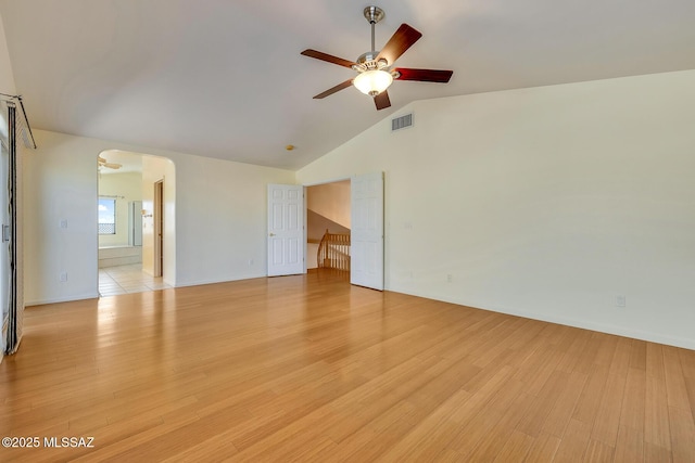 empty room featuring ceiling fan, light hardwood / wood-style floors, and vaulted ceiling