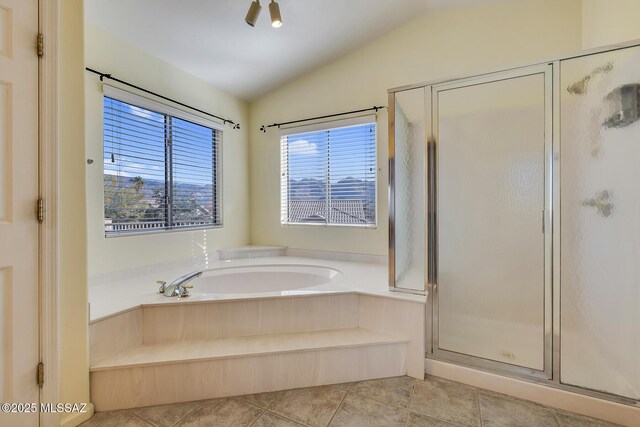 bathroom with tile patterned floors, separate shower and tub, and vaulted ceiling