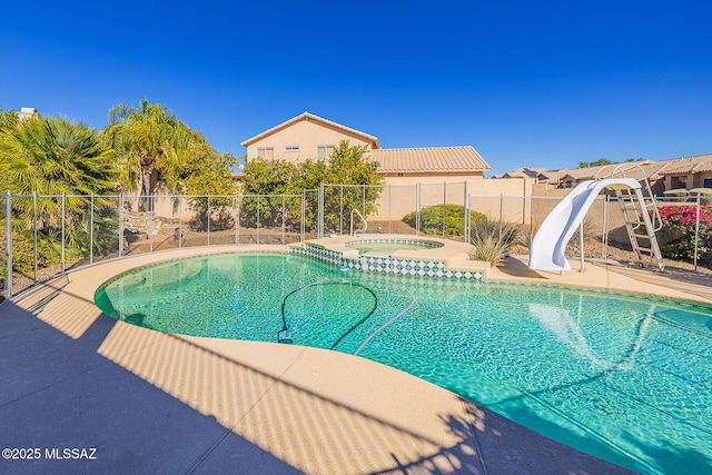 view of pool featuring an in ground hot tub and a water slide