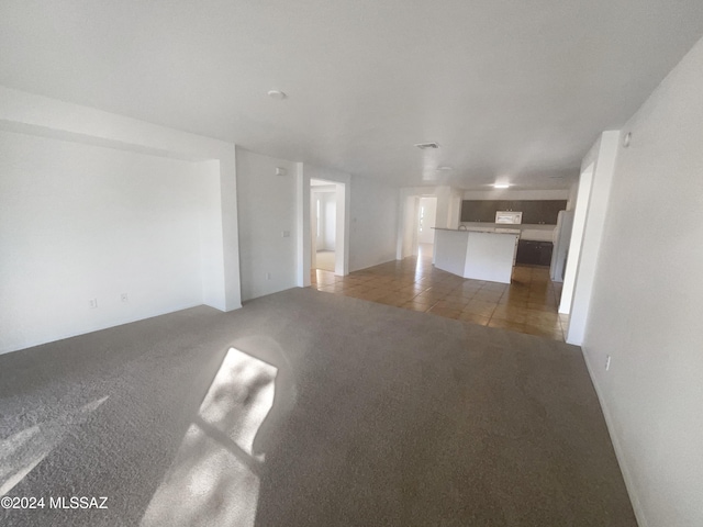 spare room featuring dark colored carpet