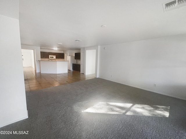 unfurnished living room featuring dark carpet