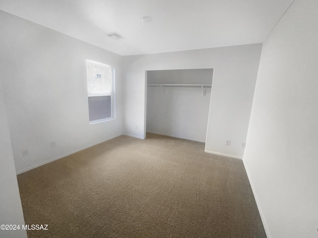 unfurnished bedroom featuring carpet floors and a closet