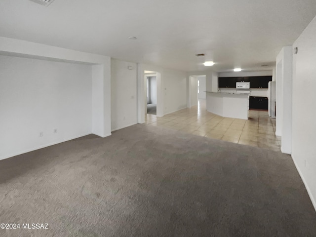 unfurnished living room featuring light carpet