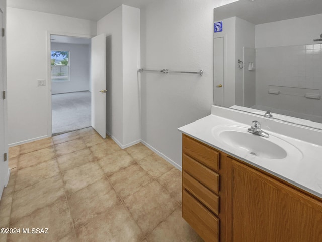 bathroom with a shower, vanity, and tile patterned flooring