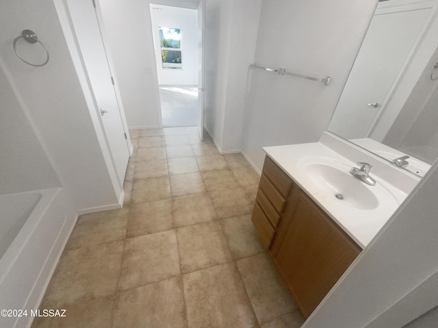 bathroom featuring tile patterned flooring, vanity, and a tub