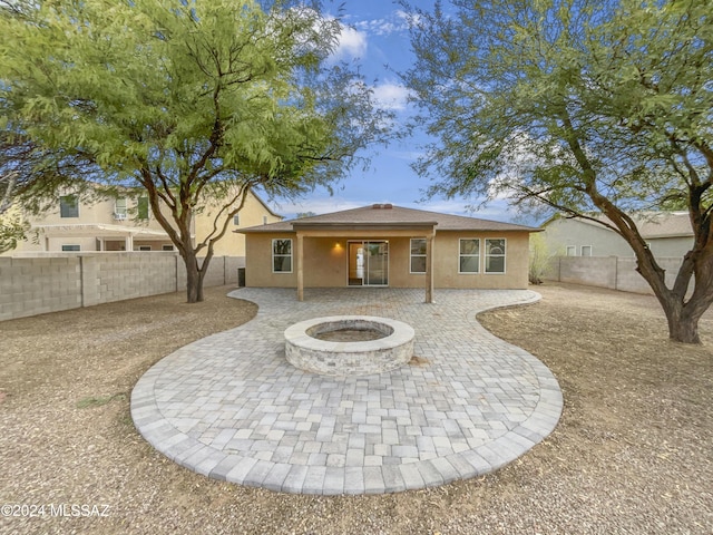 rear view of house with a fire pit and a patio area