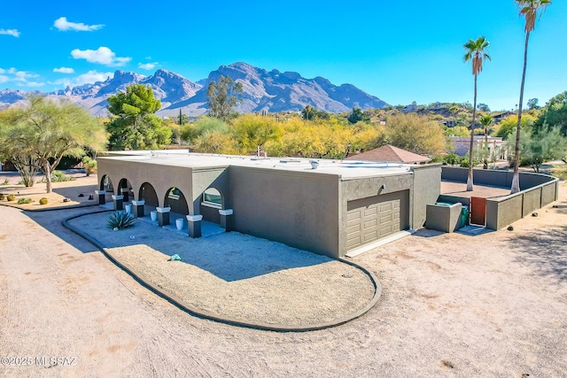 back of property with a mountain view and a garage