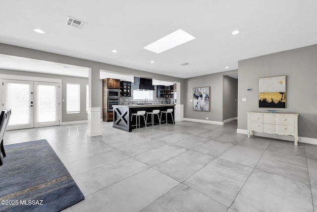 kitchen featuring premium range hood, a kitchen bar, sink, tasteful backsplash, and stainless steel appliances