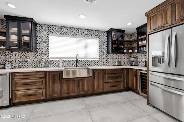 kitchen featuring light tile patterned flooring, sink, wine cooler, stainless steel appliances, and dark brown cabinets