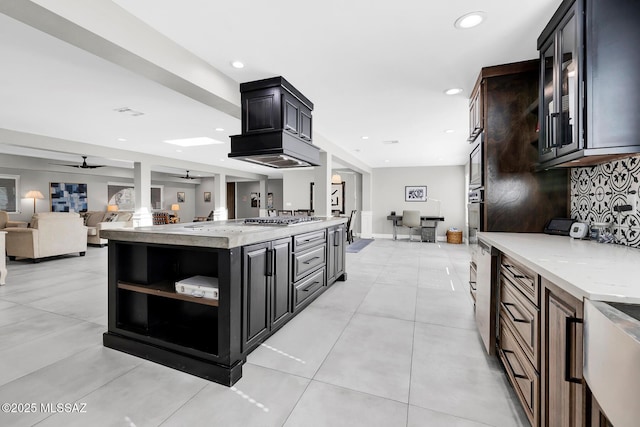 kitchen featuring light tile patterned floors, ceiling fan, backsplash, stainless steel appliances, and light stone counters