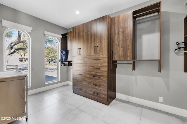 walk in closet with light tile patterned floors