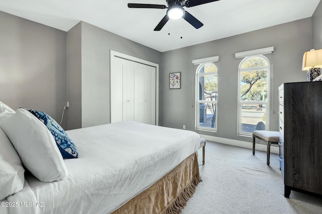 bedroom featuring light colored carpet, a closet, and ceiling fan