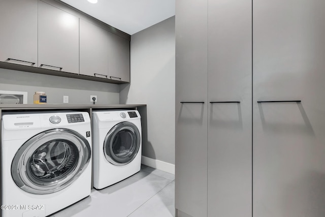 washroom with washer and clothes dryer and cabinets