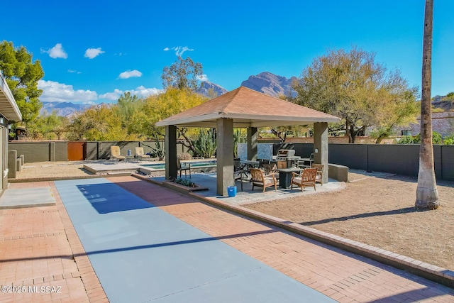 surrounding community with a mountain view, a gazebo, a patio area, and a pool