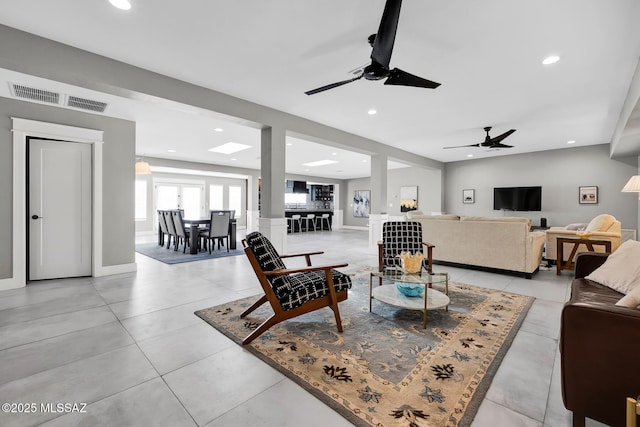 living room featuring light tile patterned flooring and ceiling fan