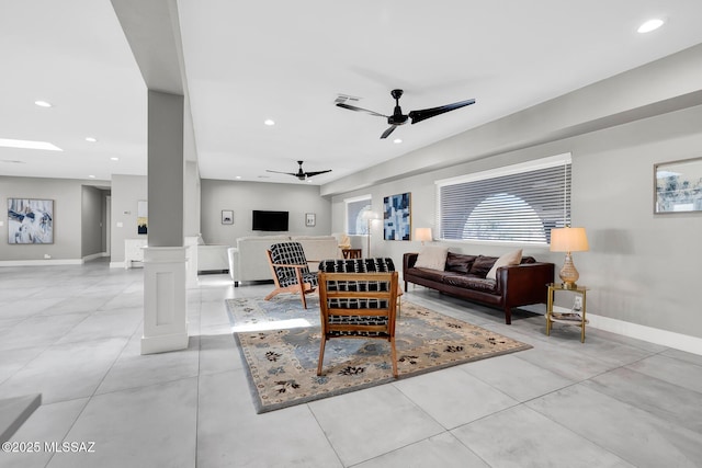 tiled living room featuring decorative columns and ceiling fan